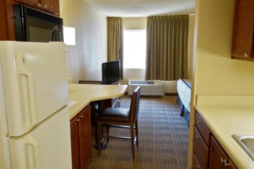 a kitchen with a refrigerator and a dinning room at Extended Stay America Select Suites - Dallas - Richardson in Richardson