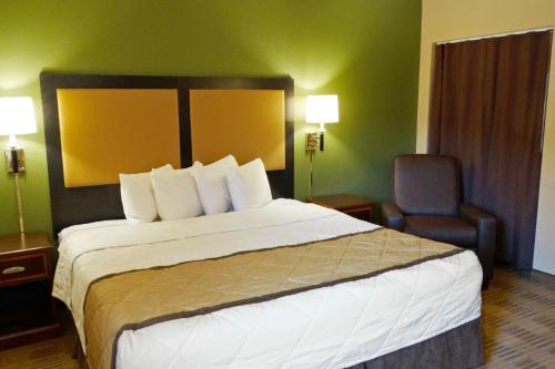 a hotel room with a large bed and a chair at Extended Stay America Select Suites - Dallas - Richardson in Richardson