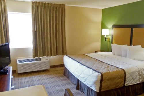a hotel room with a bed and a television at Extended Stay America Select Suites - Dallas - Richardson in Richardson