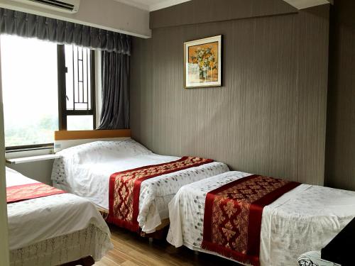 Habitación de hotel con 2 camas y ventana en Hong Kong Tai San Guest House (Burlington Branch), en Hong Kong