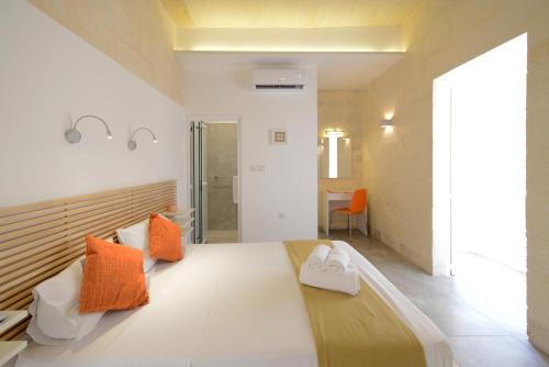 a room with a bed with orange and white pillows at Vallettastay Lovely House Private Rooms in Valletta