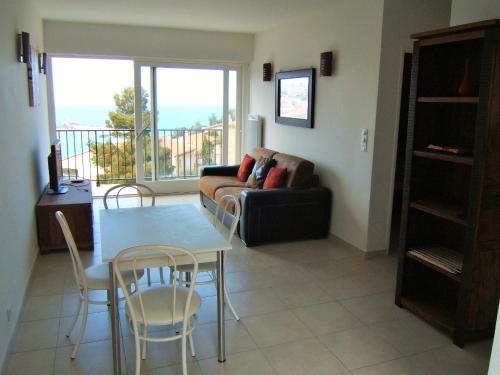 un salon avec un canapé, une table et des chaises dans l'établissement 4HC65 Appartement avec vue sur baie de Collioure, à Collioure