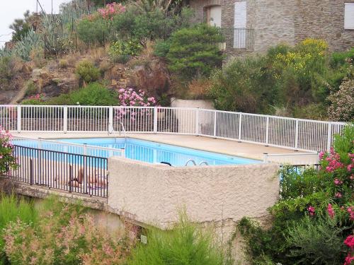 - une piscine avec une clôture blanche et des fleurs dans l'établissement 4HC65 Appartement avec vue sur la baie, à Collioure