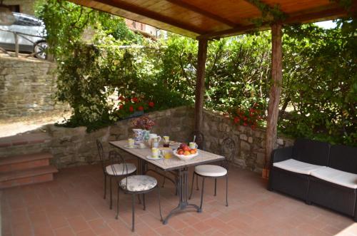 uma mesa e cadeiras sentadas num pátio em Agriturismo Il Monte - Piscina tra gli Ulivi, Maneggio con Cavalli e WIFI em Monte Santa Maria Tiberina