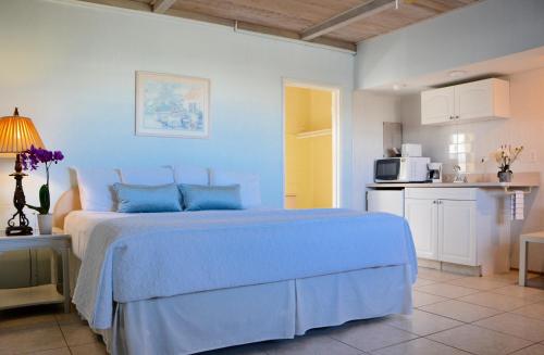 a blue bedroom with a bed and a kitchen at Sea Turtle Inn in Vero Beach