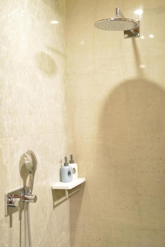 a bathroom with a shower with a shower head at Rock&Wood Cozy House in Hangzhou