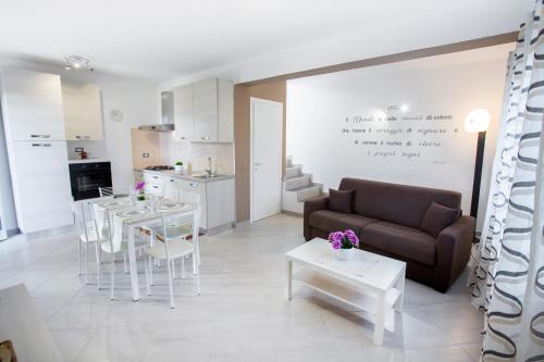 a living room with a couch and a table and chairs at Le Zagare in Lascari