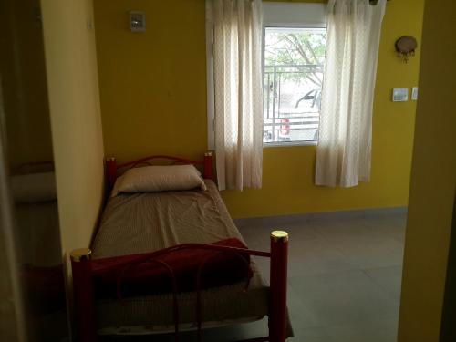 a small bedroom with a bed and a window at La Rinconada in Las Grutas