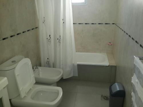 a white bathroom with a toilet and a sink at La Rinconada in Las Grutas