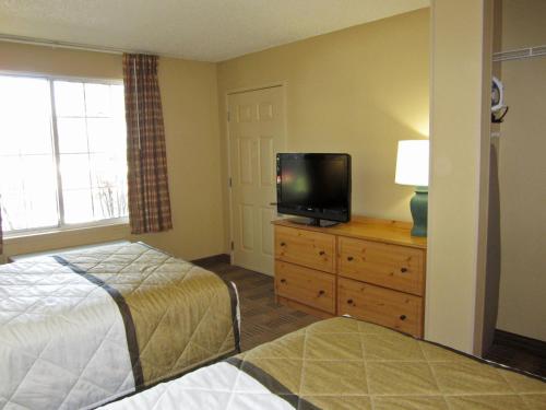 a bedroom with a bed and a flat screen tv at Extended Stay America Suites - Dallas - Las Colinas - Carnaby St in Irving