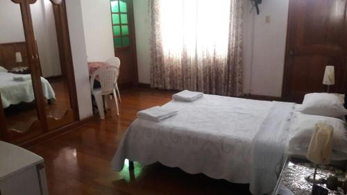 a bedroom with a bed with a table and a mirror at Hostal Camiluz in Nazca
