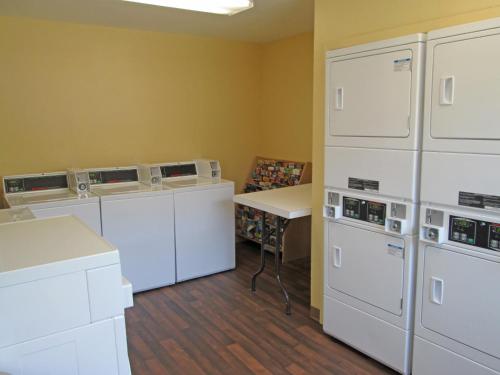 a laundry room with white appliances and a table at Extended Stay America Suites - Dallas - Las Colinas - Carnaby St in Irving