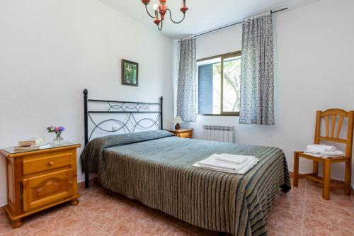 a bedroom with a bed and a table and a window at aMatalasviñas in Piedralaves