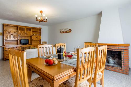 a dining room with a table and chairs and a fireplace at aMatalasviñas in Piedralaves