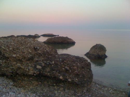 a group of rocks in the water at sunset at B&B alla Canale in Vasto