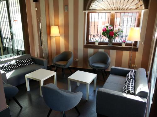 a waiting room with couches and chairs and a window at Hotel Puerta del Arco in Tudela de Duero