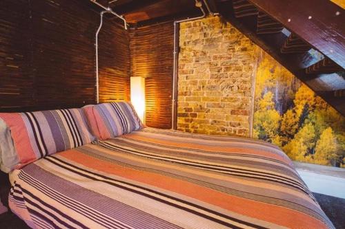 マーゲイトにあるBrooklyn lodgeのレンガの壁の客室で、大型ベッド1台を利用できます。