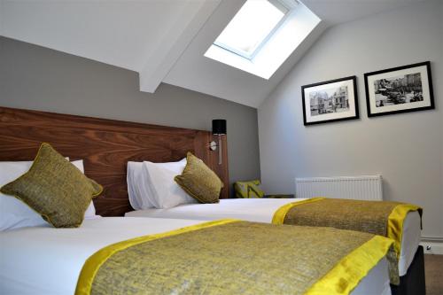 a bedroom with two beds and a skylight at New Park Hotel in Carmarthen