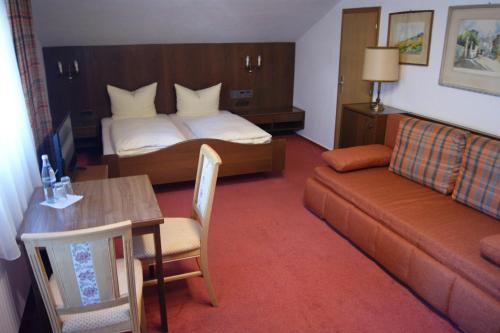 ein Hotelzimmer mit einem Bett und einem Sofa in der Unterkunft Gästehaus Charlotte in Bayrischzell