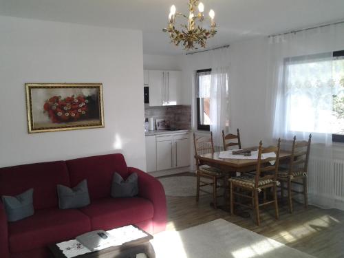 a living room with a red couch and a table at Haus Florian in Grainau