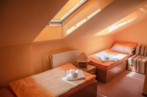 Schlafzimmer im Dachgeschoss mit 2 Betten und einem Fenster in der Unterkunft Penzion Vinárna U Hroznu in Veselí nad Moravou