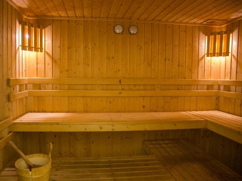 a wooden sauna with a bench and two clocks at Pontalaia Apartamentos Turísticos in Sagres
