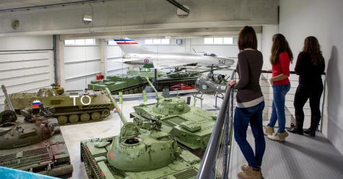 a group of people looking at tanks in a museum at Tourist farm Pri Andrejevih in Narin