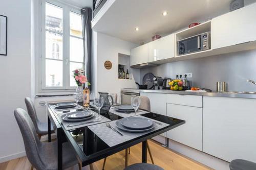 une cuisine avec une table et des chaises dans une pièce dans l'établissement ANGLE DROIT- LOFT CHARMANT ET ATYPIQUE, CLIMATISATION, Vieux-Nice, à Nice