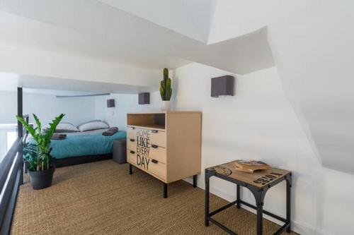 une chambre avec un lit, une commode et une table dans l'établissement ANGLE DROIT- LOFT CHARMANT ET ATYPIQUE, CLIMATISATION, Vieux-Nice, à Nice