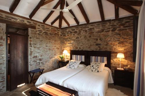 a bedroom with a large bed in a stone wall at El Añadío in Vilches