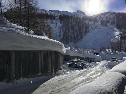 a snow covered road with cars parked on a mountain at Cozy bilocale apartment in Breuil-Cervinia
