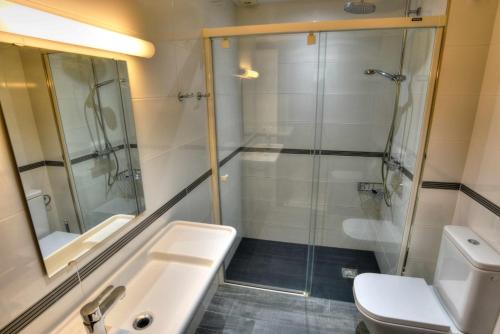 uma casa de banho com um chuveiro, um lavatório e um WC. em C16013 Club de Mar em Sant Feliu de Guíxols