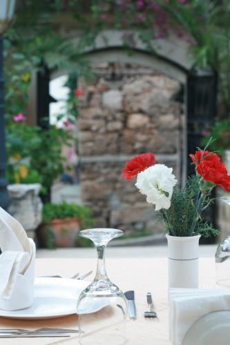a table with a glass vase with red and white flowers at Dogan Hotel in Antalya