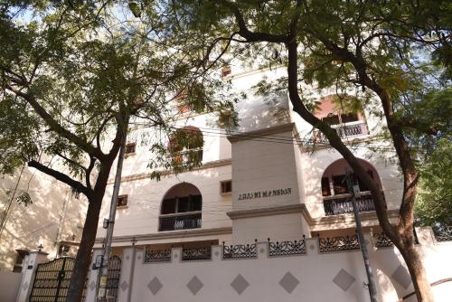 a white building with trees in front of it at anjani mansion in Hyderabad