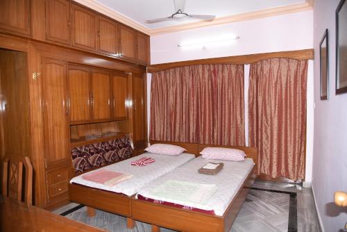 a bedroom with a bed with wooden cabinets at anjani mansion in Hyderabad