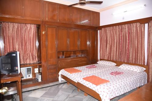 a bedroom with a bed with wood paneling and a television at anjani mansion in Hyderabad