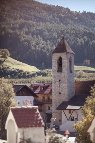 a building with a clock tower in a village at Kircherhof in Bressanone