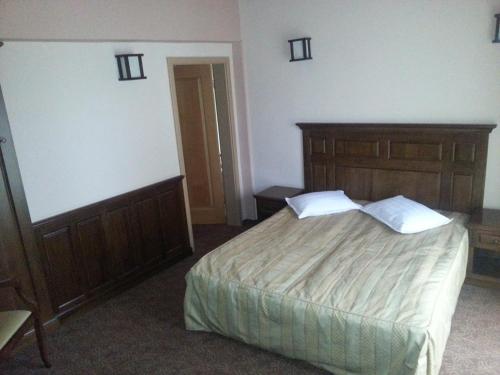 a bedroom with a large bed with a wooden headboard at Hanul Bran in Bran