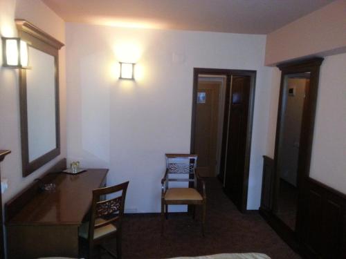 a room with a desk and a table and a mirror at Hanul Bran in Bran