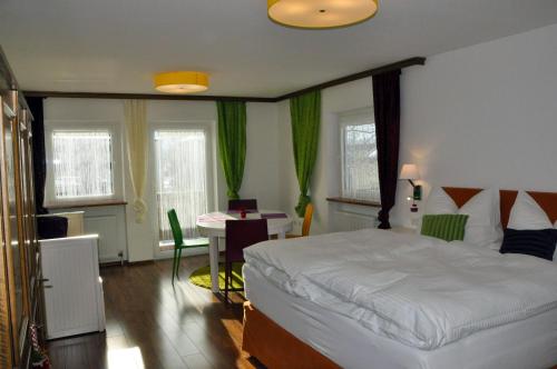 a bedroom with a bed and a table and chairs at Gästehaus Anna in Grossarl