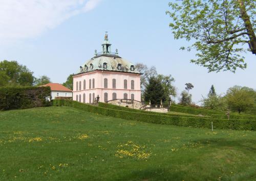 a building on top of a grassy hill at Hotel garni Sonnenhof in Reichenberg