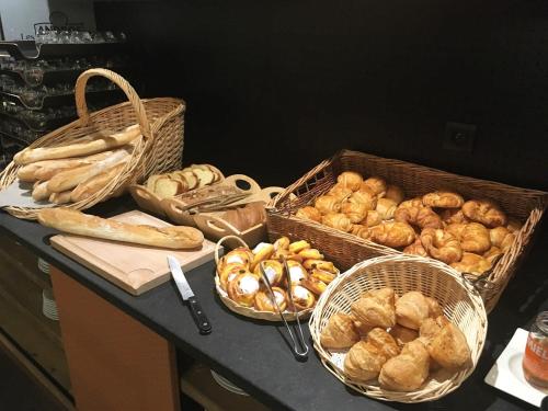 a counter with baskets of bread and baskets of pastries at Hotel de la Jamagne & Spa in Gérardmer