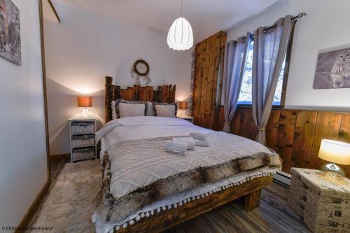 - une chambre avec un grand lit dans une pièce dotée de murs en bois dans l'établissement Le Vanilee - Les Chalets Spa Canada, à La Malbaie