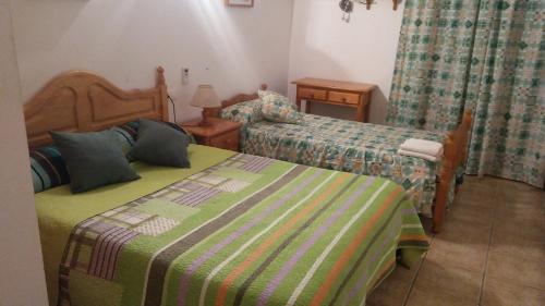 SorbasにあるHostal El Arrecifeの小さなベッドルーム(ベッド2台、ランプ付)