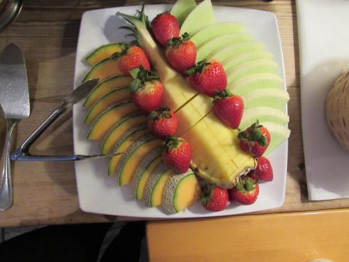 a plate of fruit with bananas and strawberries on a table at Carter House Inns in Eureka