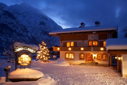 a building with a christmas sign in the snow at Landhaus Marion in Holzgau