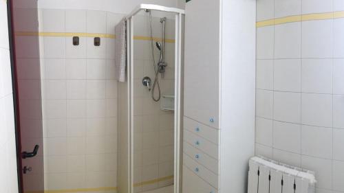 a shower in a bathroom with white tiles at Studio CENTRAL 2 in Aosta