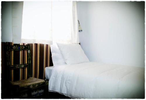 a bedroom with a white bed and a window at Casa Vitória Guest House in Évora