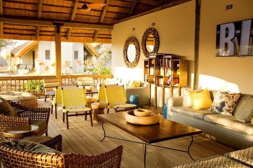 a lobby with couches and chairs and a table at Shearwater's Explorers Village in Victoria Falls