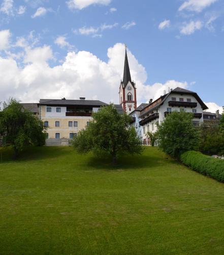 a green field in front of a building with a church at Appartementhaus Novak in Mariapfarr
